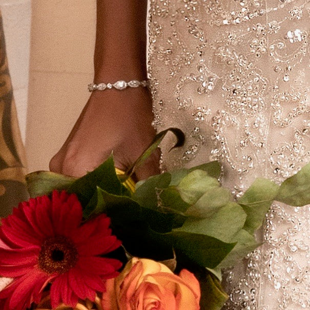 Wrist of Model wearing the Airelle Cubic Zirconia Bracelet with a Bouquet in her hand.