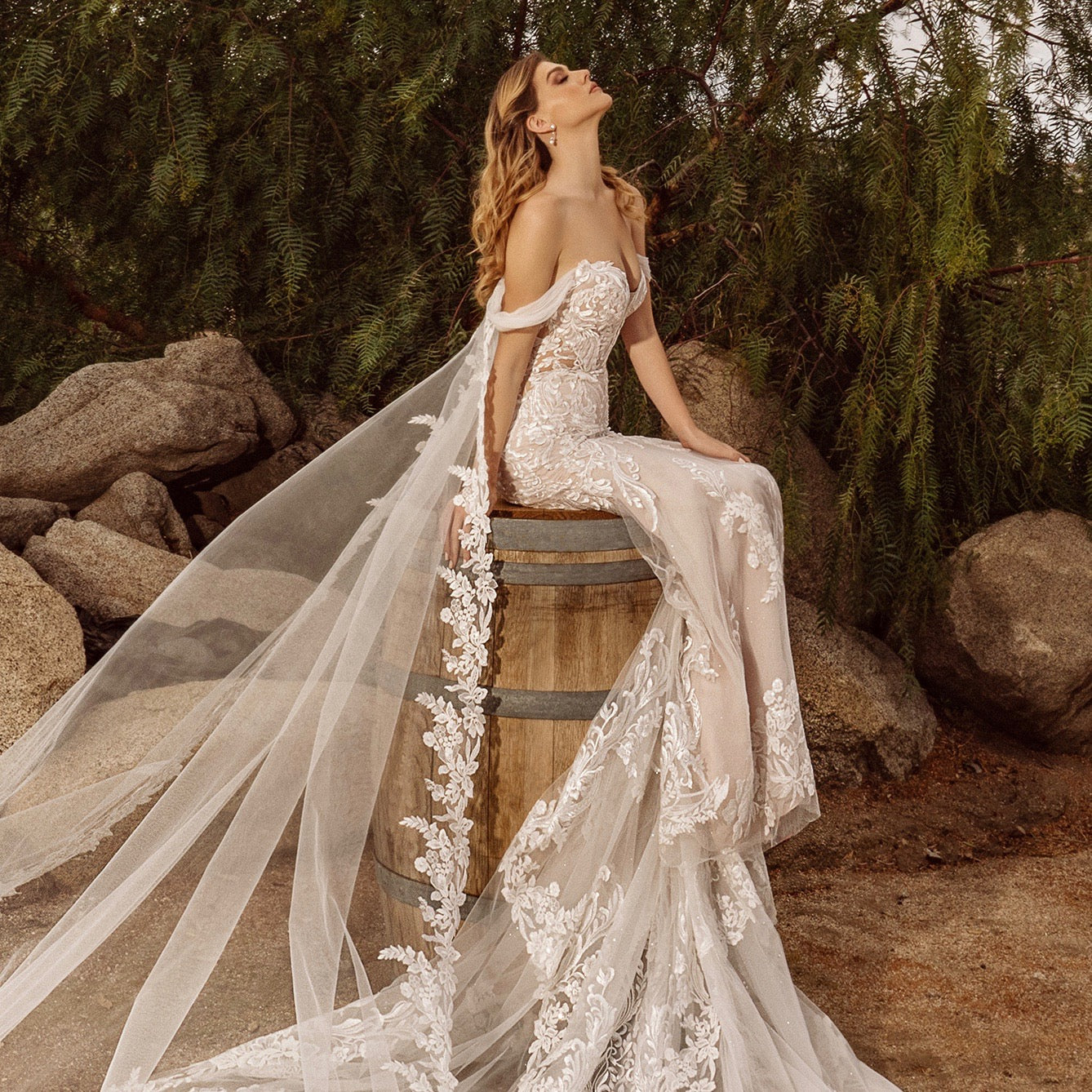 Gorgeous image of a Bride sitting on a barrel wearing a Kitty Chen Bridal gown and the Rose Pearl Dangle Earrings.