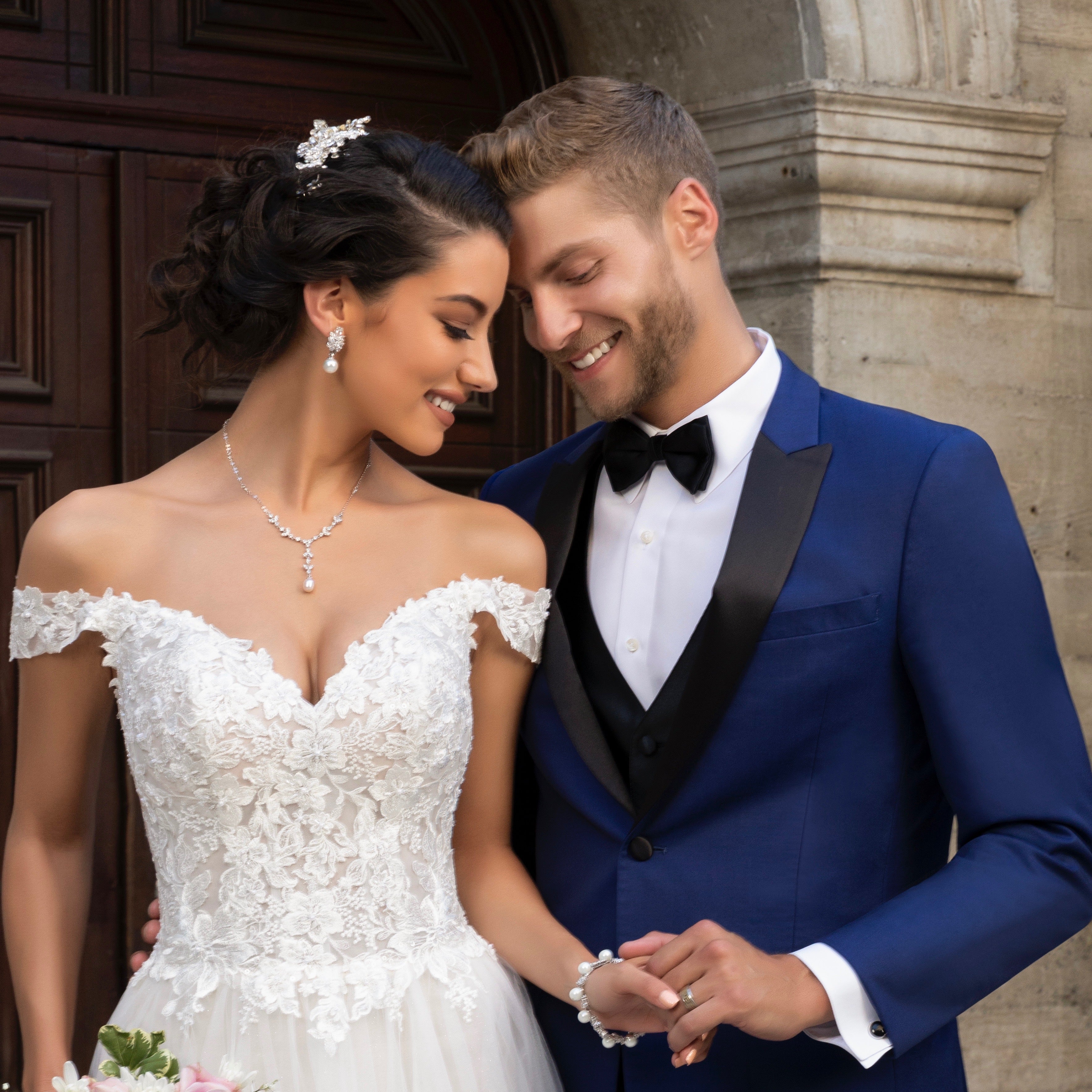 Bride and Groom holding hands. Bride is wearing the Luisa Earrings and the Primrose Necklace
