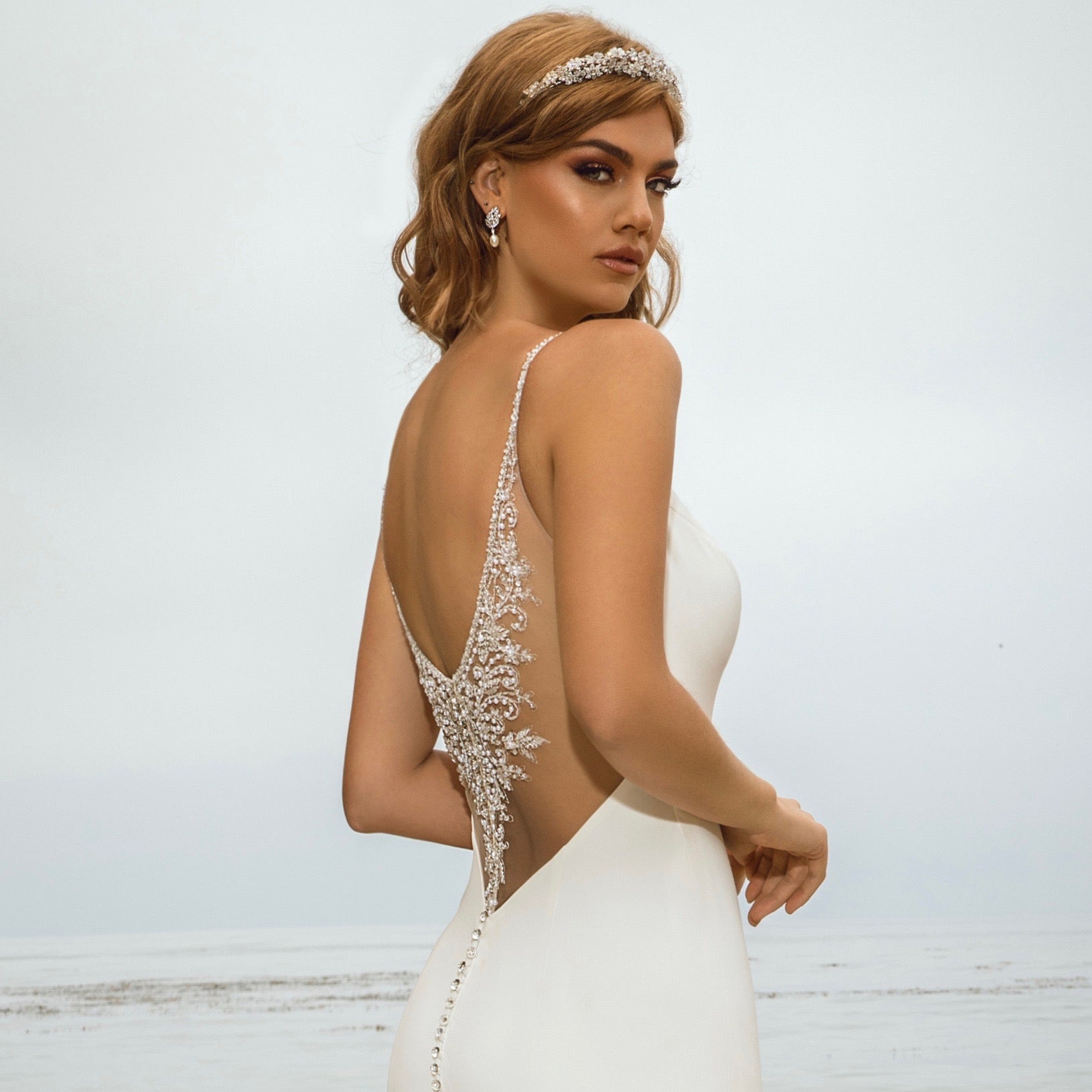 Kiya Freshwater Pearl and Crystal Earrings on a model at the Beach.